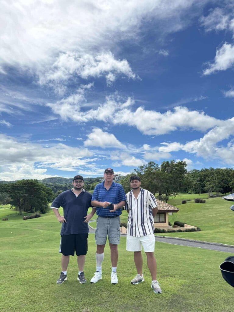 Peter and his sons playing golf at Splendido Taal Golf Club with Taal Lake in the background